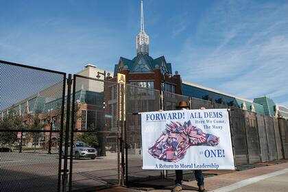 El manifestante Stephen Parlato sostiene un cartel fuera del Centro de Wisconsin antes de la Convención Nacional Demócrata en Milwaukee, el 17 de agosto de 2020