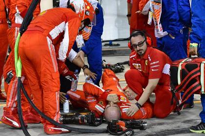 El mecánico Francesco Cigarini en el piso, después de ser arrollado por Kimi Räikkonen en el Gran Premio de Bahréin 2018; el italiano, de Ferrari, encargado del neumático trasero izquierdo, sufrió la fractura de la tibia y el peroné de la pierna izquierda