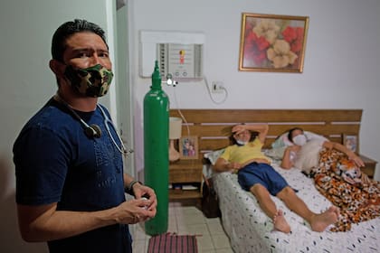 El médico brasileño de emergencias Marcos Fonseca Barbosa junto a sus padres, ambos infectados con el coronavirus, en su casa de Manaos, estado de Amazonas, Brasil, el 12 de enero de 2021