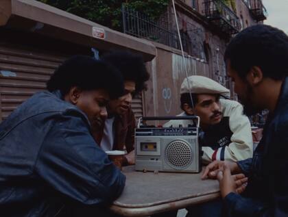 El "mensaje" de Donald Trump en el video musical de "NUEVAYoL" es escuchado por un grupo de migrantes, quienes lo reciben con incredulidad y apagan el radio (YouTube/Bad Bunny)