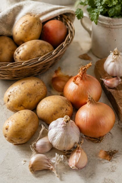 El método recomendado por un chef para que papas, cebollas y ajos duren más (Imagen ilustrativa con IA)