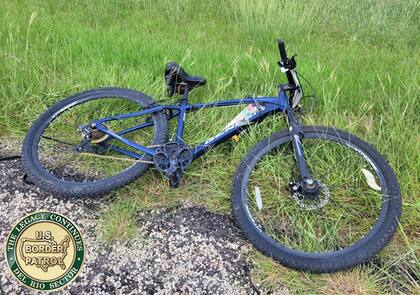 El migrante abandonó su bicicleta y corrió entre los pastizales hasta que encontró un lugar para esconderse