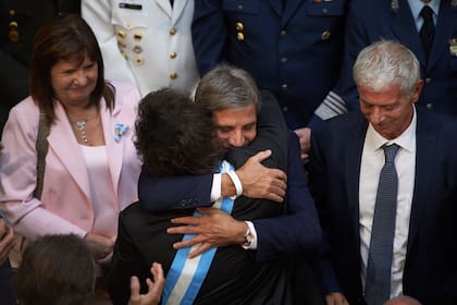 El ministro de Economía, Luis Caputo, abraza a el presidente, Javier Milei, luego de inaugurar el período de sesiones ordinarias del Congreso Nacional