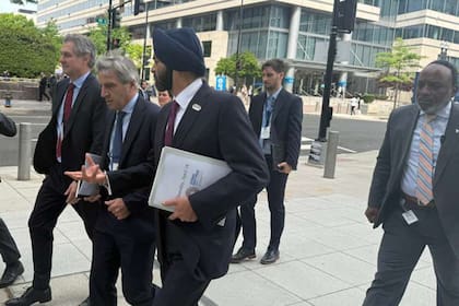 El ministro de Economía, Luis Caputoc camina desde las oficinas del FMI a las del Banco Mundial (BM), junto a su vice José Luis Daza y al presidente del BM, Ajay Banga