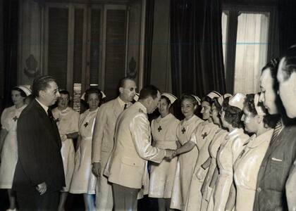 El ministro del Interior, general Luis Perlinger, saludando a los miembros de la delegación de la Cruz Roja destacada en San Juan con motivo del terremoto. 10 de febrero de 1944