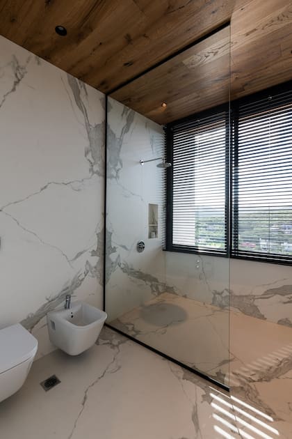 El modelo Estuario E01, utilizado en los baños de la casa, permite espejar la veta y revestir de piso a techo con la menor junta posible, dado su gran formato