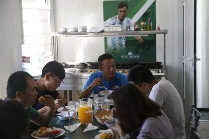 El momento de la comida; atrás, el póster de Nicolás Tagliafico