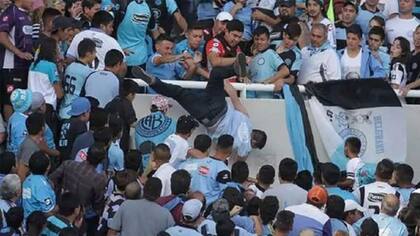 El momento en el que Balbo cae de la tribuna; lo empujan Martín Vergara (de rojo), Cristian Oliva (de gorra blanca), Pablo Robledo (el primero parado a la derecha de Oliva) y Matías Oliva (parado al lado de Robledo)