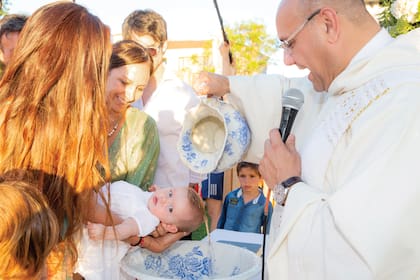 El momento en el que el padre Fabricio Maranzana, párroco del Dulcísimo Nombre de Jesús, vierte el agua bautismal. 