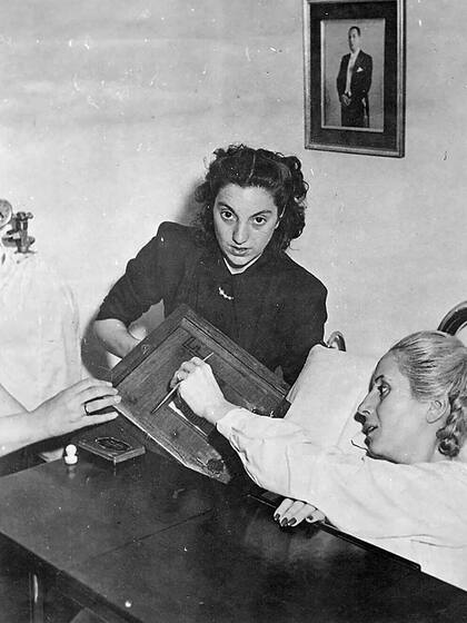 El momento en el que le acercan la urna a Eva Perón para que participe en las primeras elecciones que incluyeron a la mujer argentina, en 1951; la histórica foto en el policlínico en el que se encontraba internada fue tomada por Pinélides Fusco