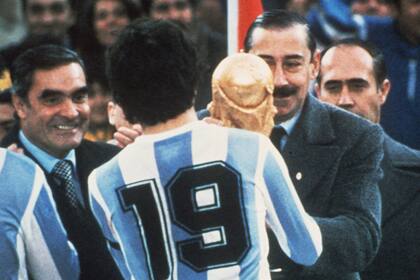 El momento en que Daniel arella, capitán del seleccionado, recibe la Copa de manos del general Videla, presidente de facto, luego de ganar la final; muy cerca, observa el almirante Massera