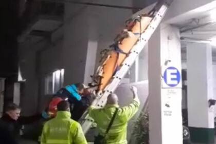 El momento en que el hombre fue retirado del pulmón del edificio por personal de Rescate y Bomberos