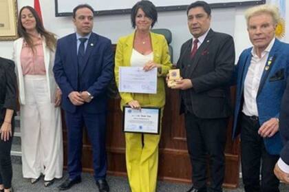 El momento en que Pamela David recibe su reconocimiento en el Salón Comuneros del Congreso Nacional paraguayo