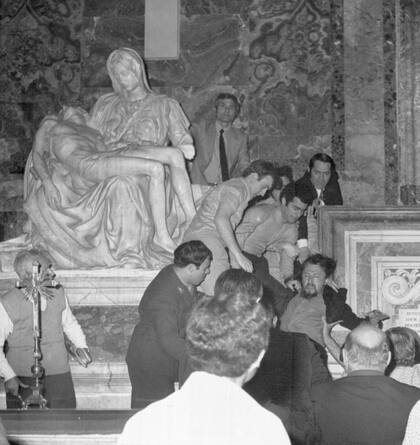 El momento en que un grupo de personas arrastran a Laszlo Toth, (derecha) atacante de "La Piedad" de Miguel Ángel, en San Pedro, después de que rompiera la escultura con un martillo