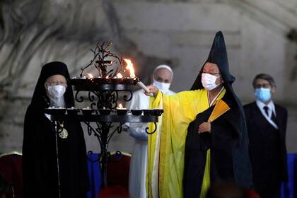 El monje budista Shoten Minegishi enciende una vela por la paz junto a Bartolomé I, Patriarca de Constantinopla, el Papa Francisco y Haim Korsia, Gran Rabino de Francia, durante la ceremonia en la plaza frente al Ayuntamiento de Roma