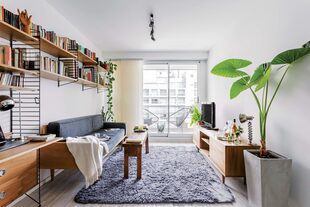 El mueble a medida hecho por Calyfornio sirve como escritorio y continúa como biblioteca desplegándose sobre el sillón.