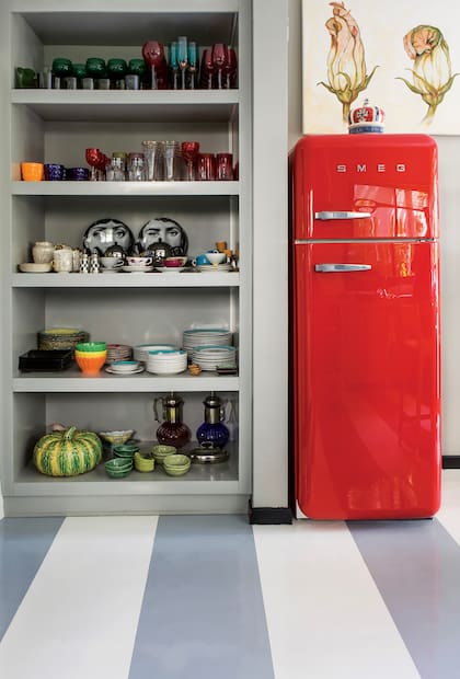 El mueble abierto deja ver la vajilla colorida, un elemento decorativo más.