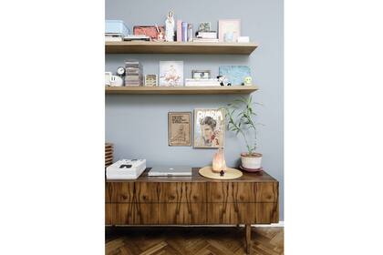 El mueble antiguo se combina aquí con dos estantes modernos y objetos cuidadosamente elegidos para lograr un todo equilibrado y moderno. La elección del color de la pared es un acierto que cierra el estilo del living