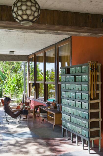 El mueble de ferretería comprado en el Mercado de Pulgas aún conserva las leyendas escritas a mano que indicaban el contenido de cada cajoncito. Sillón tipo BKF plegable con asiento de lona