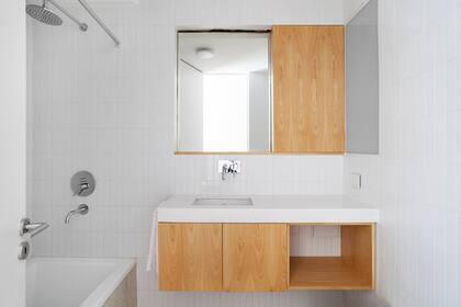 El mueble suspendido es de madera como la puerta del botiquín (Noma Estudio). Cerámicos (Acuarela). Griferías Temple (FV).