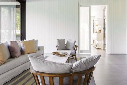 El muro que une este rincón del quincho con la cocina se revistió con un machihembrado de madera pintado de blanco. “Este espacio es muy grande y nos pareció que lo unificaba con calidez”.