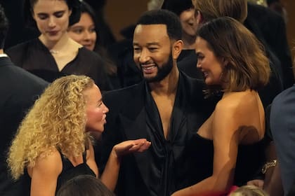 El músico John Legend, en el centro, junto a su esposa, la modelo y conductora Chrissy Teigen, a su derecha; ambos se conocieron en 2006 en el set del video musical del cantante para su sencillo "Stereo"; tienen cuatro hijos