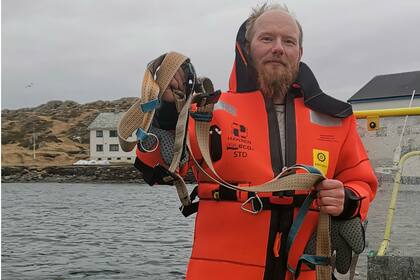 El noruego Joergen Ree Wiig, de la directiva de Pesca, sostiene el arnés de la ballena