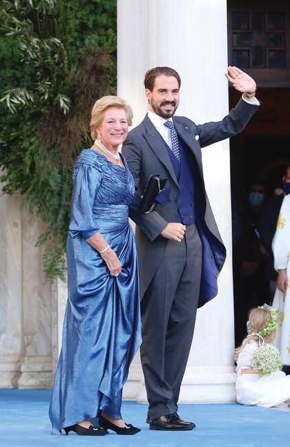 El novio llegó acompañado de su madre, Ana María, que lució un vestido de la diseñadora griega Celia Kritharioti. Lo acompañó con un collar de perlas de tres vueltas con una cruz que llevó en su propio enlace con Constantino, y pendientes de diamantes con una gran perla en forma de lágrima.