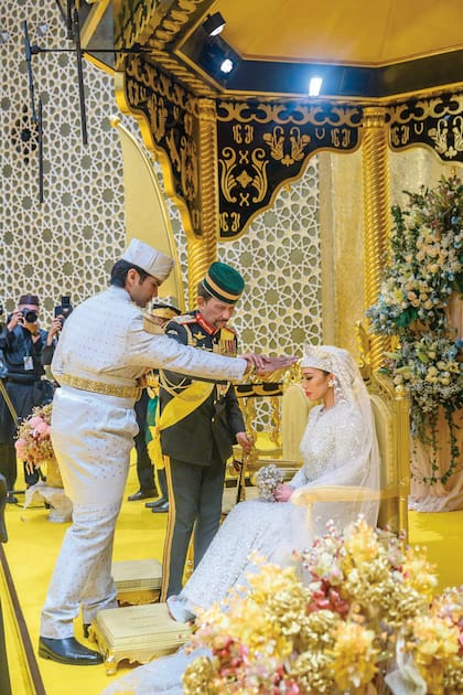 El novio, Yang Amat Mulia Pengiran Muda Bahar, unge a su futura mujer, la princesa Azemah, en una de las ceremonias que se celebraron por la boda real. Detrás, el sultán Haji Hassanal Bolkiah, el padre de la novia. 