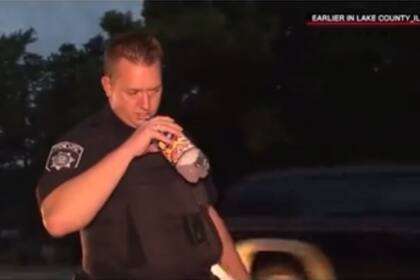 El oficial huele la botella de la bebida del hombre para asegurarse de que no ingirió alcohol