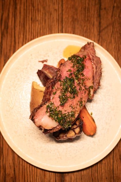 El ojo de bife, generoso, que sale con chimichurri, papas y ajo