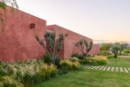 El paisajismo (Blas Spina) diseñó un jardín de gramíneas, herbáceas y arbustos autóctonos de poco mantenimiento y dispuesto de manera suelta para un aspecto natural y silvestre