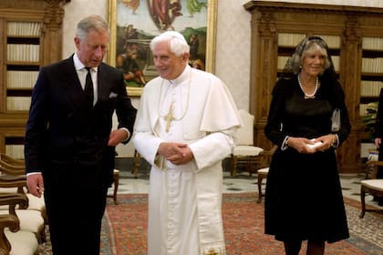 El Papa Benedicto XVI camina con Carlos de Gran Bretaña y su esposa Camilla durante una reunión en su biblioteca privada en el Vaticano, el 27 de abril de 2009