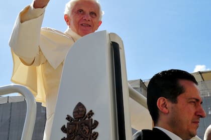 El papa Benedicto XVI saluda mientras está parado en su papamóvil con su mayordomo Paolo Gabriele, al llegar a una audiencia general, el 25 de abril de 2012 en la plaza de San Pedro en el Vaticano