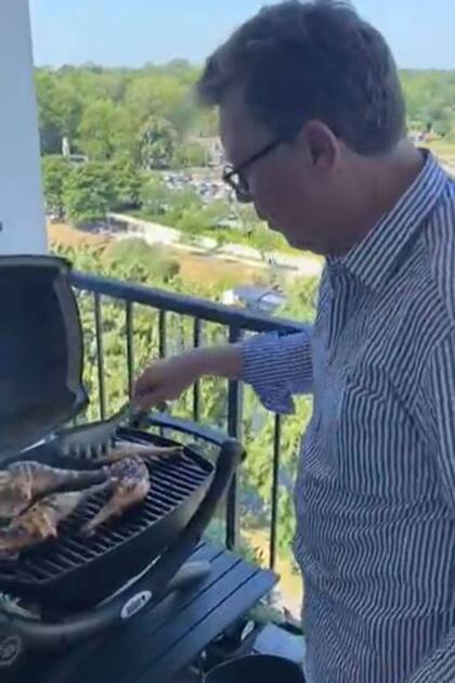 El papá del tiktoker Ladistino asa unas piezas de pollo en la particular parrilla que el joven tiene en París