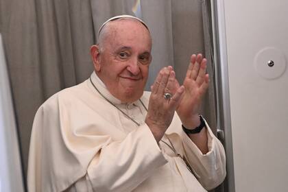 El papa Francisco aplaude el domingo 5 de febrero de 2023 durante una conferencia de prensa a bordo del avión papal, en dirección a Roma. (Tiziana Fabi/Foto compartida vía AP)
