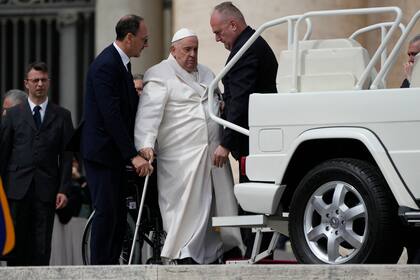 El papa Francisco es ayudado a ponerse de pie tras la audiencia general de este miércoles en la Plaza San Pedro, en el Vaticano. (AP/Alessandra Tarantino)
