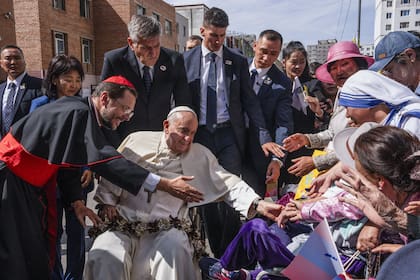 El Papa Francisco es recibido por el Cardenal Giorgio Marengo, izquierda, Prefecto Apostólico de Ulaan Bator, y fieles reunidos fuera de la Prefectura Apostólica 