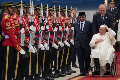 El Papa Francisco es recibido por el ministro de Asuntos Religiosos de Indonesia, Yaqut Cholil Qoumas, en el centro, poco después de aterrizar en el aeropuerto internacional Soekarno Hatta de Yakarta, el martes 3 de septiembre de 2024.
