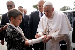 El papa Francisco firma el yeso de un chico a la salida del hospital en Roma