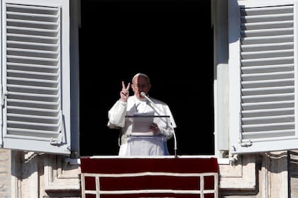 El papa Francisco hace un gesto desde la ventana de su estudio que da a la Plaza de San Pedro mientras pronuncia la oración del mediodía del Ángelus, en el Vaticano, el domingo 18 de diciembre de 2016.