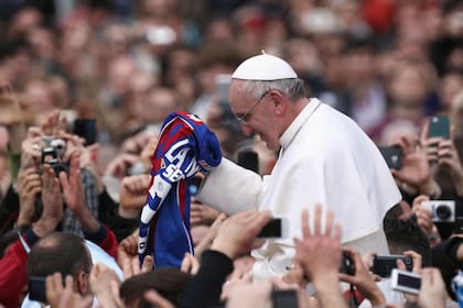 El Papa Francisco recibe una camiseta de San Lorenzo, mientras saluda a los fieles antes de su primera bendición "Urbi et Orbi" desde el balcón de la Basílica de San Pedro durante la Misa de Pascua, el 31 de marzo de 2013
