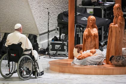 El papa Francisco reza frente a un belén elaborado en la ciudad cisjordana de Belén en el salón Pablo VI del Vaticano, el sábado 7 de diciembre de 2024