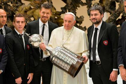 El Papa Francisco sostiene el trofeo de la Copa Libertadores mientras posa con representantes del equipo de fútbol argentino San Lorenzo durante una audiencia general el miércoles en la sala de Pablo VI en el Vaticano el 20 de agosto de 2014.
