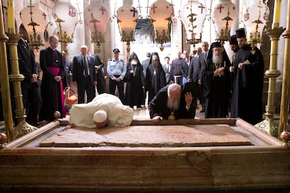 El Papa Francisco y el Bartolomé I, patriarca de Constantinopla, se arrodillan para besar la Piedra de la Unción, tradicionalmente declarada como la piedra donde el cuerpo de Jesús fue preparado para el entierro, en la Iglesia del Santo Sepulcro, en Jerusalén, Israel, el domingo 25 de mayo de 2014.