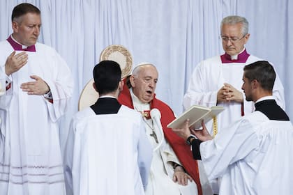 El Papa lee con ayuda durante una misa al aire libre en Edmonton, Canadá