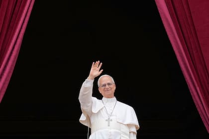 El papa León XIV se asoma al balcón central de la basílica de San Pedro en el Vaticano para bendecir a la multitud en la plaza, el 11 de mayo de 2025. (AP Foto/Gregorio Borgia)