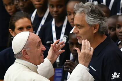 El Papa saluda a Andrea Bocelli mientras los miembros del coro Voces de Haití, de la Fundación perteneciente al tenor italiano, observan con atención. El encuentro fue en agosto de 2017