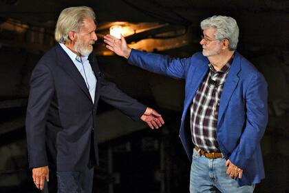El creador de "Star Wars" George Lucas, a la derecha, saluda al miembro del elenco Harrison Ford en el escenario durante la ceremonia de apertura