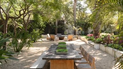 El parque que rodea la vivienda combina áreas verdes cuidadas con árboles maduros y sectores de descanso al aire libre